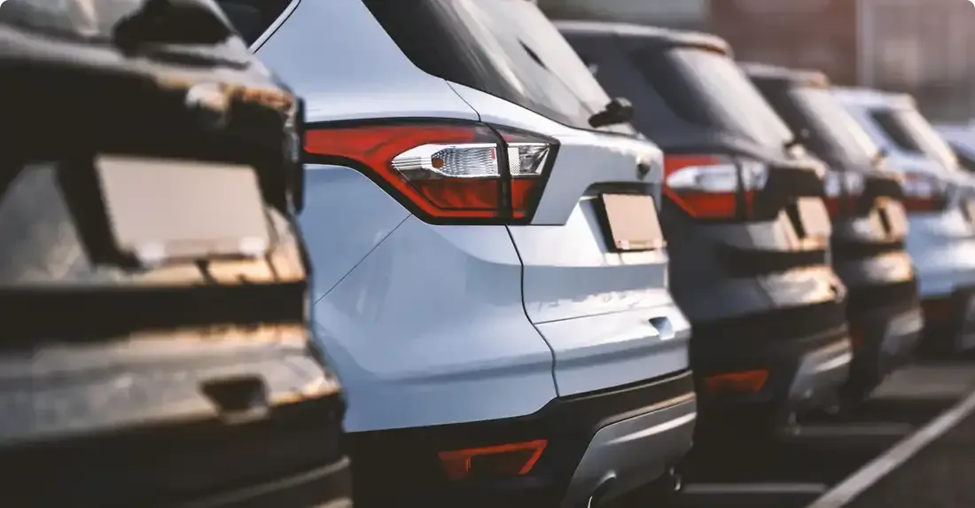 A row of cars are parked in a parking lot.