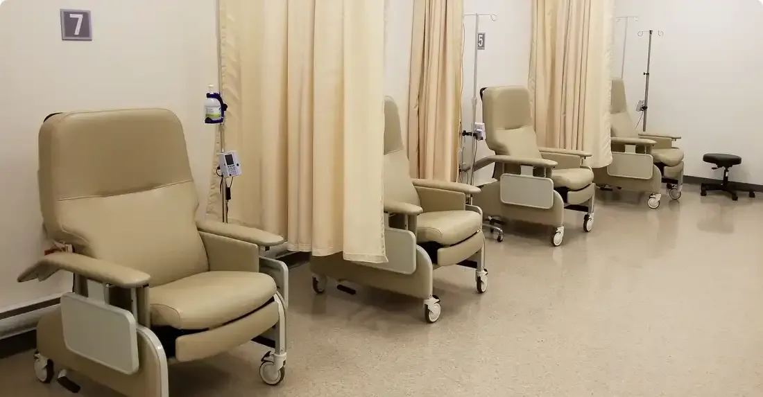 A hospital room with a row of chairs and curtains.