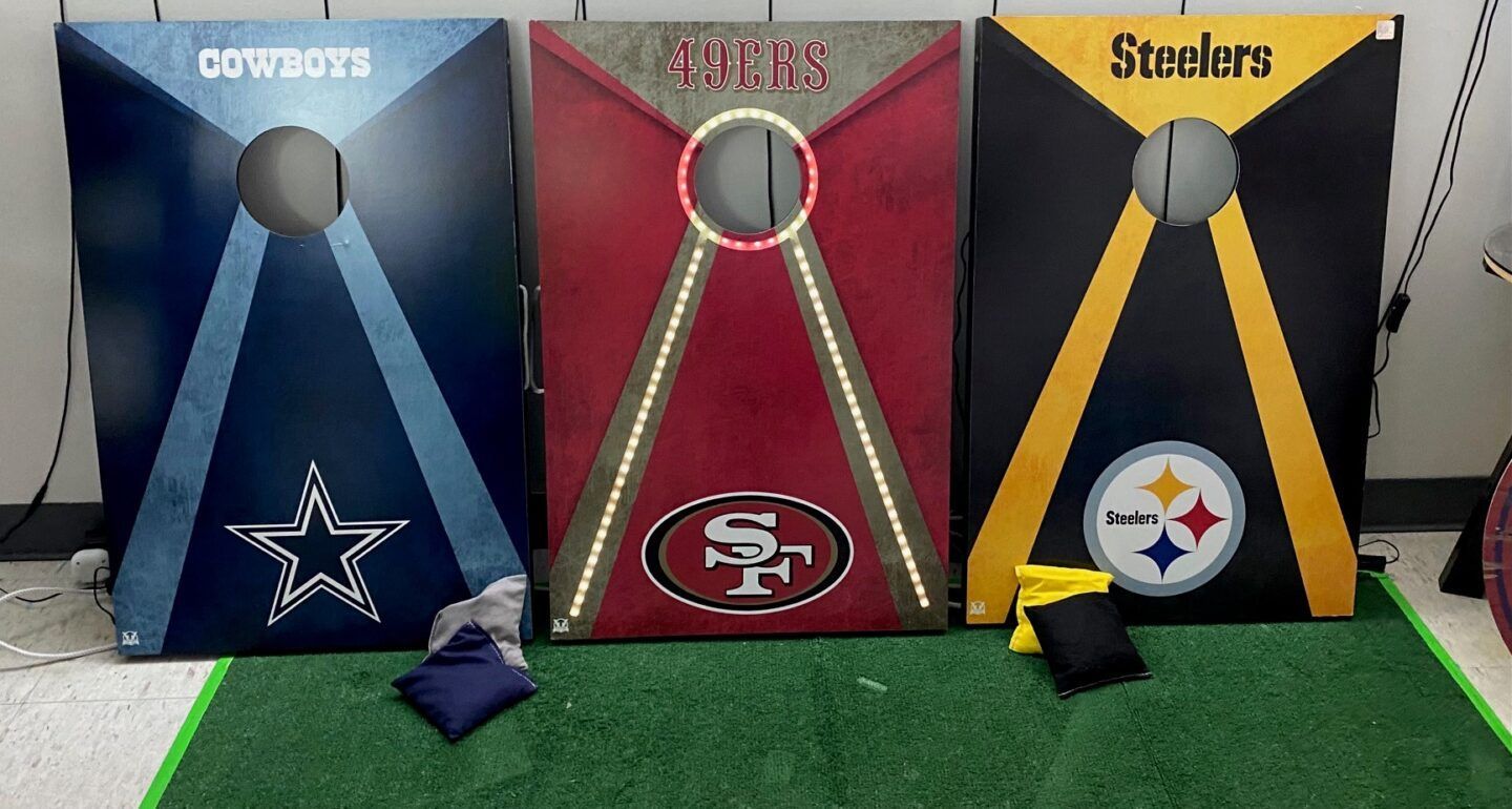 Three NFL-themed game boards for Cowboys, 49ers, and Steelers on a green floor