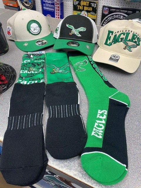Green and black Eagles socks and caps displayed on a table