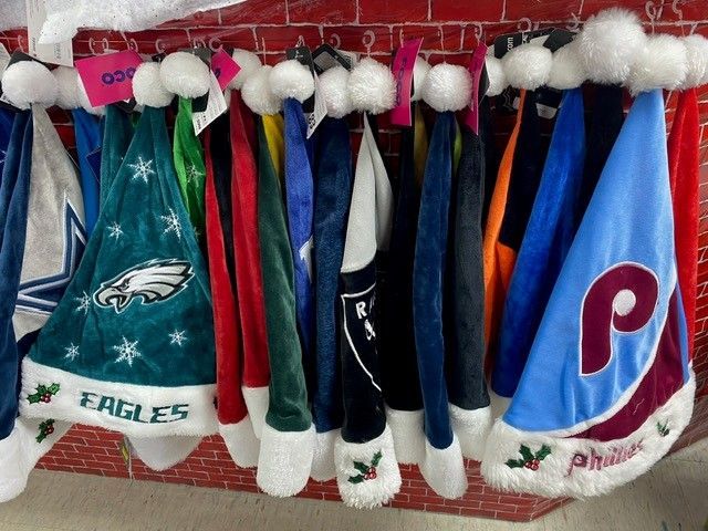 Philadelphia Eagles-themed Christmas stockings hanging on a red mantle, decorated in team colors and logos