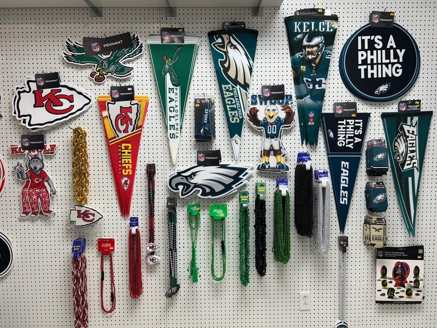 Wall display of Philadelphia Eagles and Kansas City Chiefs fan merchandise, including pennants and lanyards.