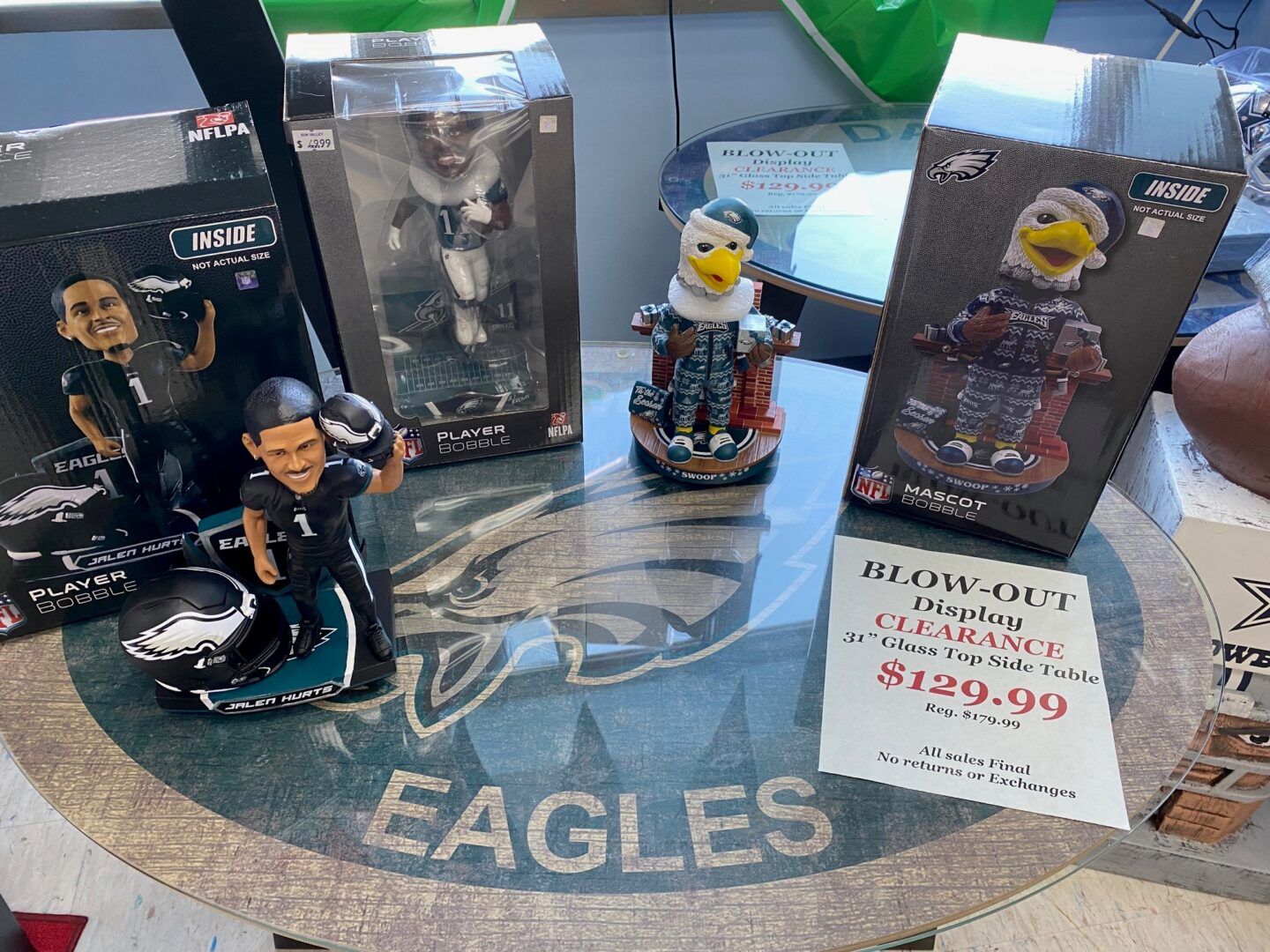 Philadelphia Eagles collectible figurines and boxed figures on a table with an Eagles logo cloth.