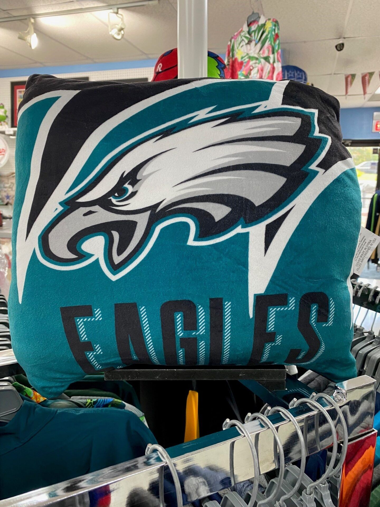Philadelphia Eagles logo on a teal plush blanket in a store display