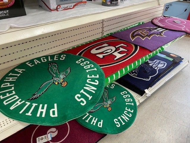 Assorted colorful Philadelphia Eagles round trays stacked on a store shelf