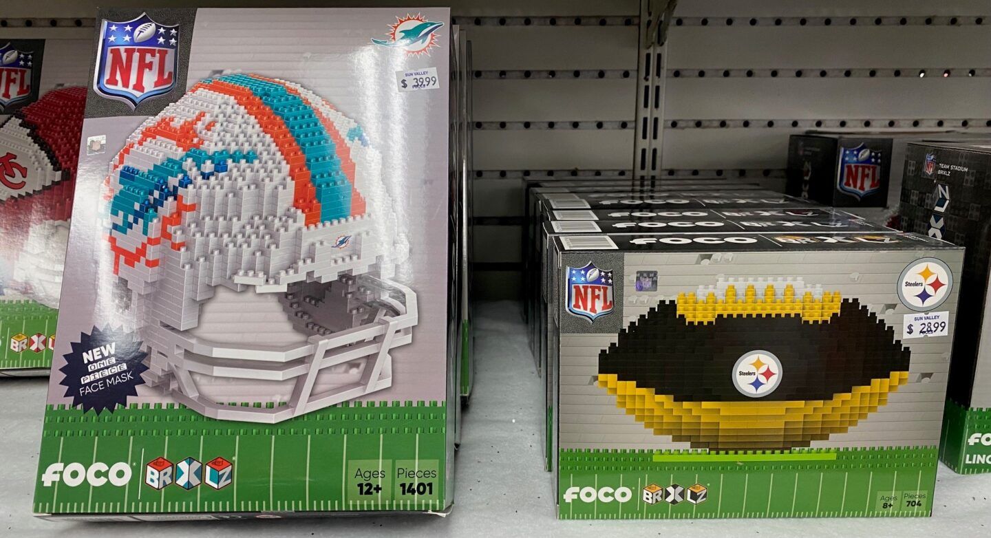 Two NFL-themed Foco air freshener boxes on a store shelf, one Dolphins and one Steelers.