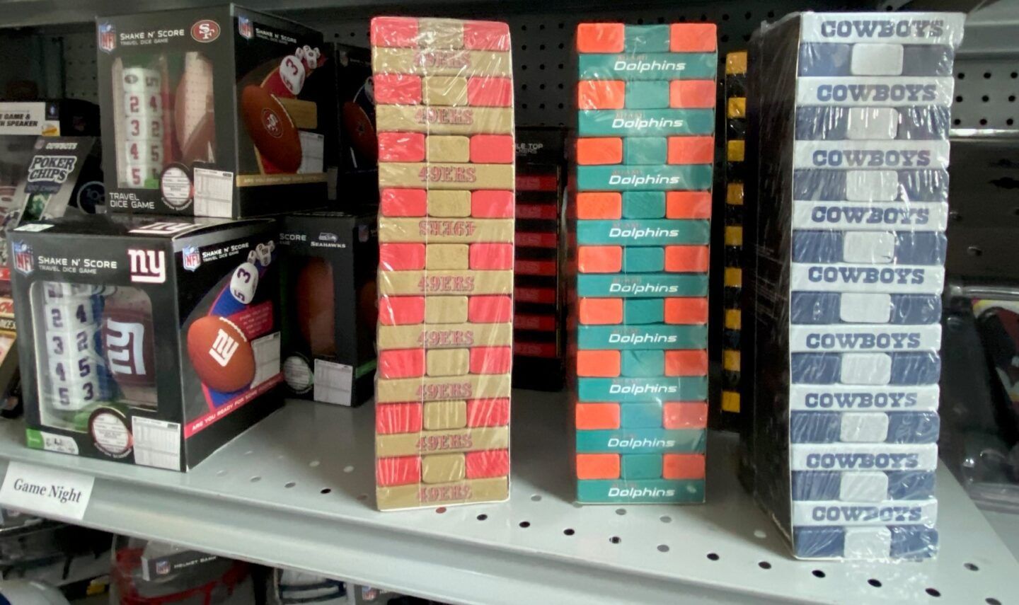 Shelved stacks of colorful boxed products in a store aisle, including red, teal, and white boxes.