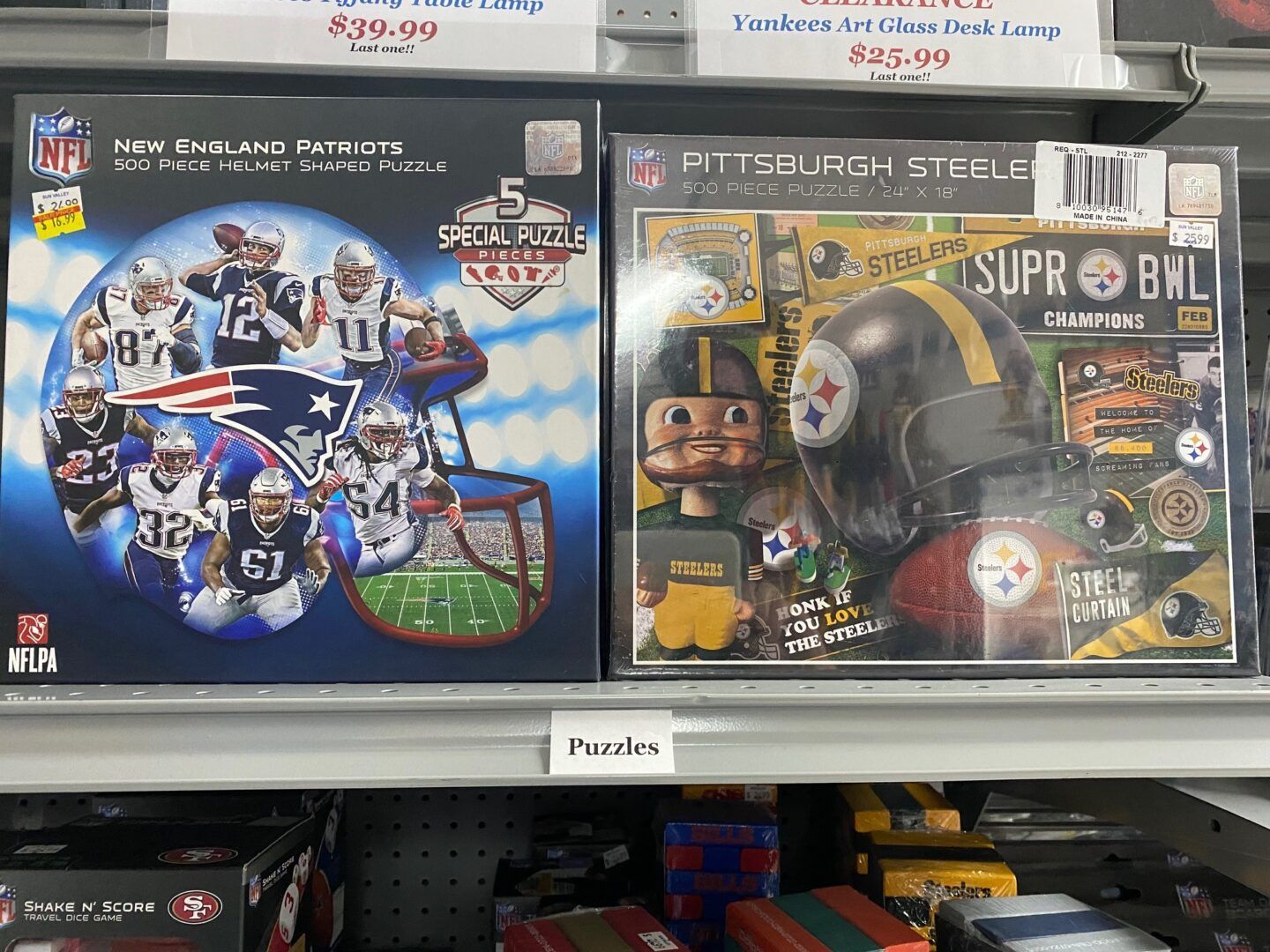 Store shelf with football trading card boxes, including Pittsburgh Steelers and Buffalo Bills sets