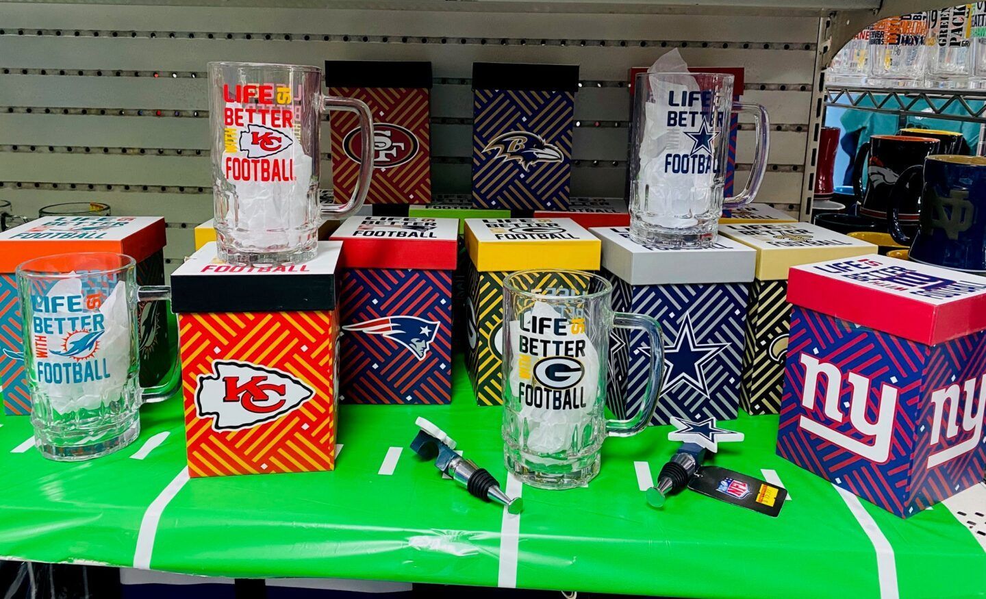 Assorted colorful beverage cans and bottles displayed on a store shelf with price tags