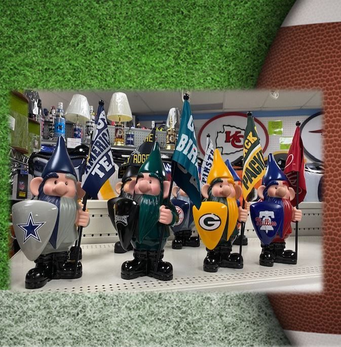 Shelf display of decorative football gnome figurines with team logos and flags in blue, green, yellow, and red