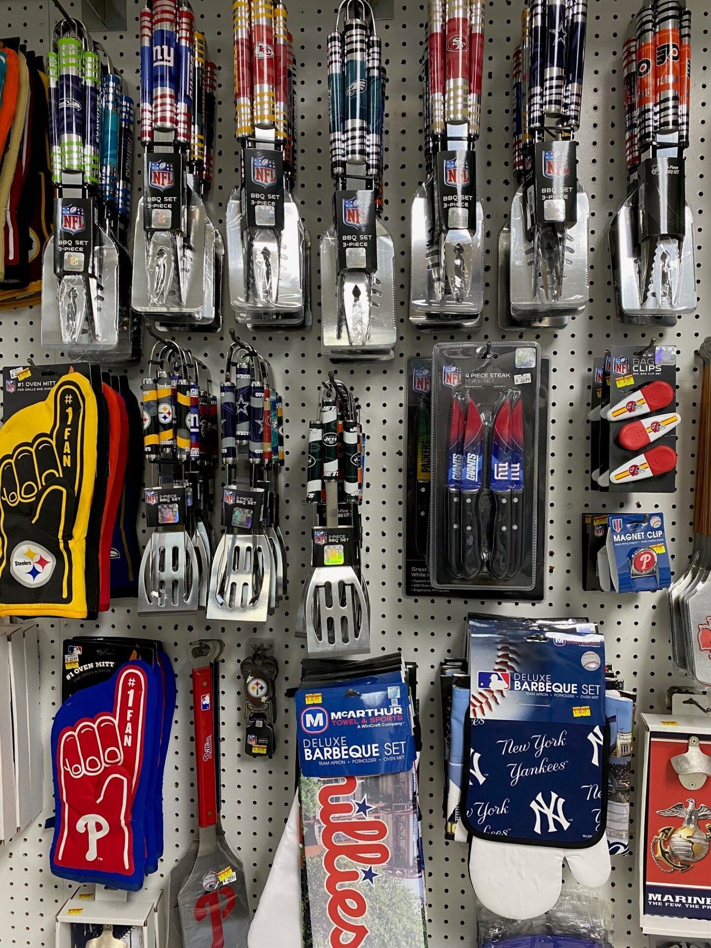 Assorted sports gloves and hand wraps hanging on a store pegboard display.