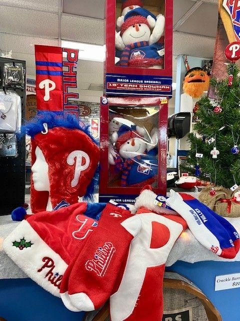 Phillies-themed holiday display with Santa ornaments, red-and-blue apparel, and a small Christmas tree
