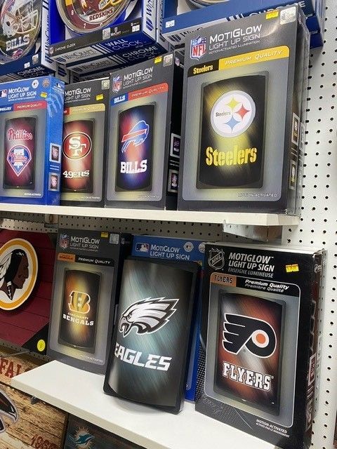NFL team logo display boxes on store shelves, including Steelers, Eagles, and Flyers.