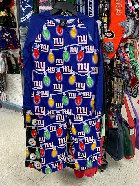 Blue New York Giants shirt with repeated logos hanging in a clothing store.