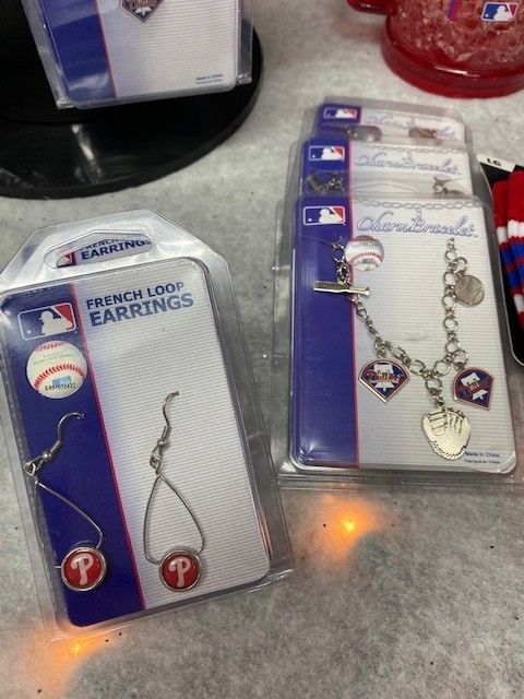 Two packaged French logo earrings and a charm bracelet with hearts on a store shelf.