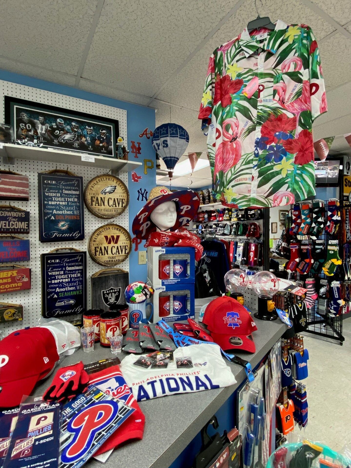 Sports-themed room filled with baseball memorabilia, caps, jerseys, pennants, and framed signs.