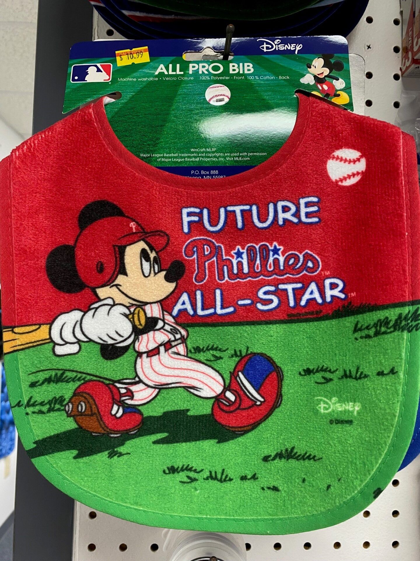 Red and green Mickey Mouse “Future All-Star” bib with Disney branding on a retail hanger.