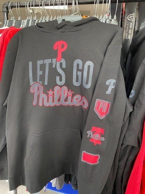 Black Philadelphia Phillies hoodie with “Let’s Go Phillies” text hanging on a clothing rack