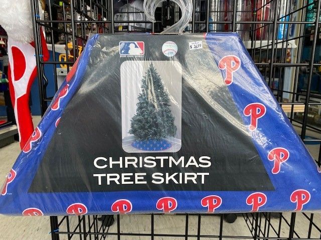 Christmas tree skirt with blue and red Philadelphia Phillies logos and a tree graphic on display.