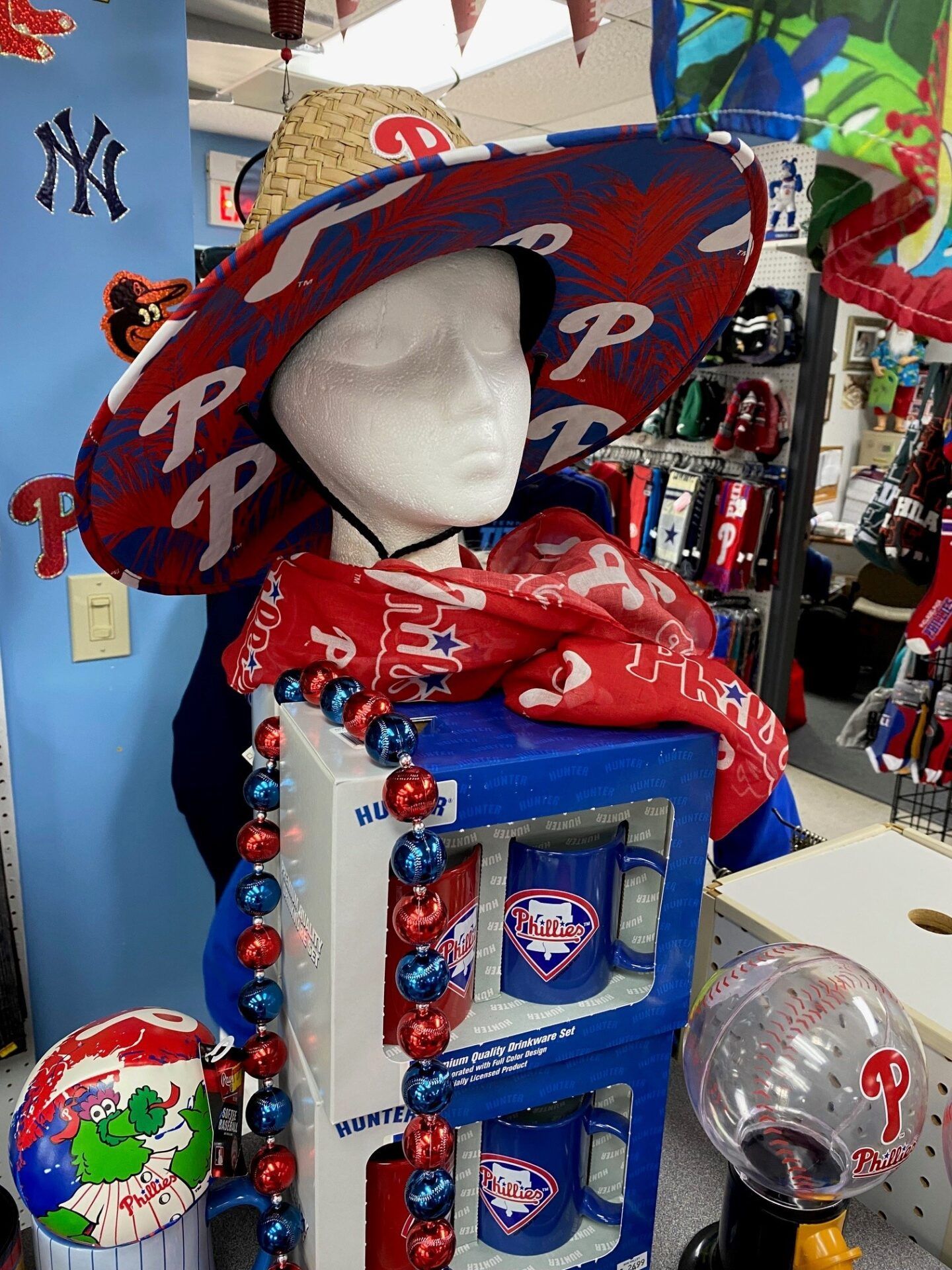 Philadelphia Phillies mannequin display in a sports store, with red cap, scarf, and jerseys.