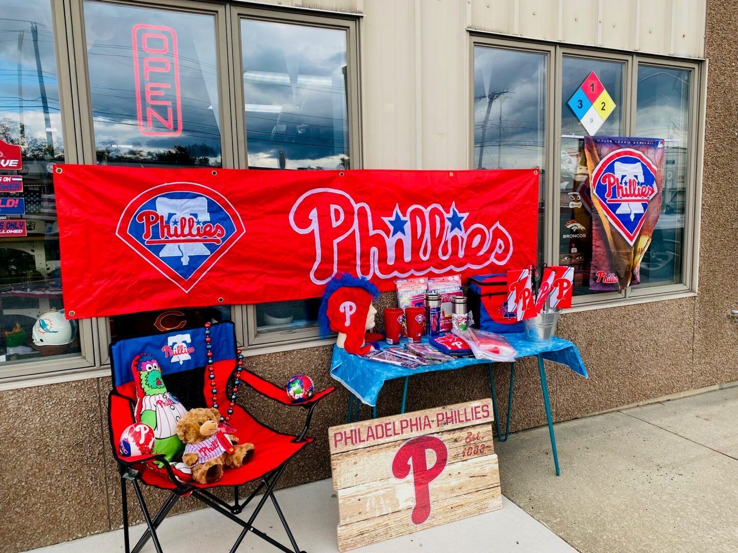 Phillies fan display with red banner, team signs, and decorated chair outside a building