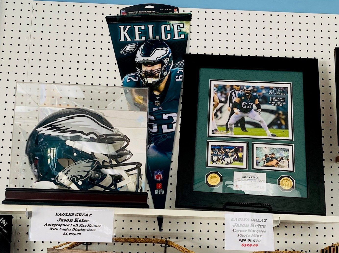 Kansas City Chiefs Travis Kelce memorabilia display with framed photo, pennant, and signed helmet