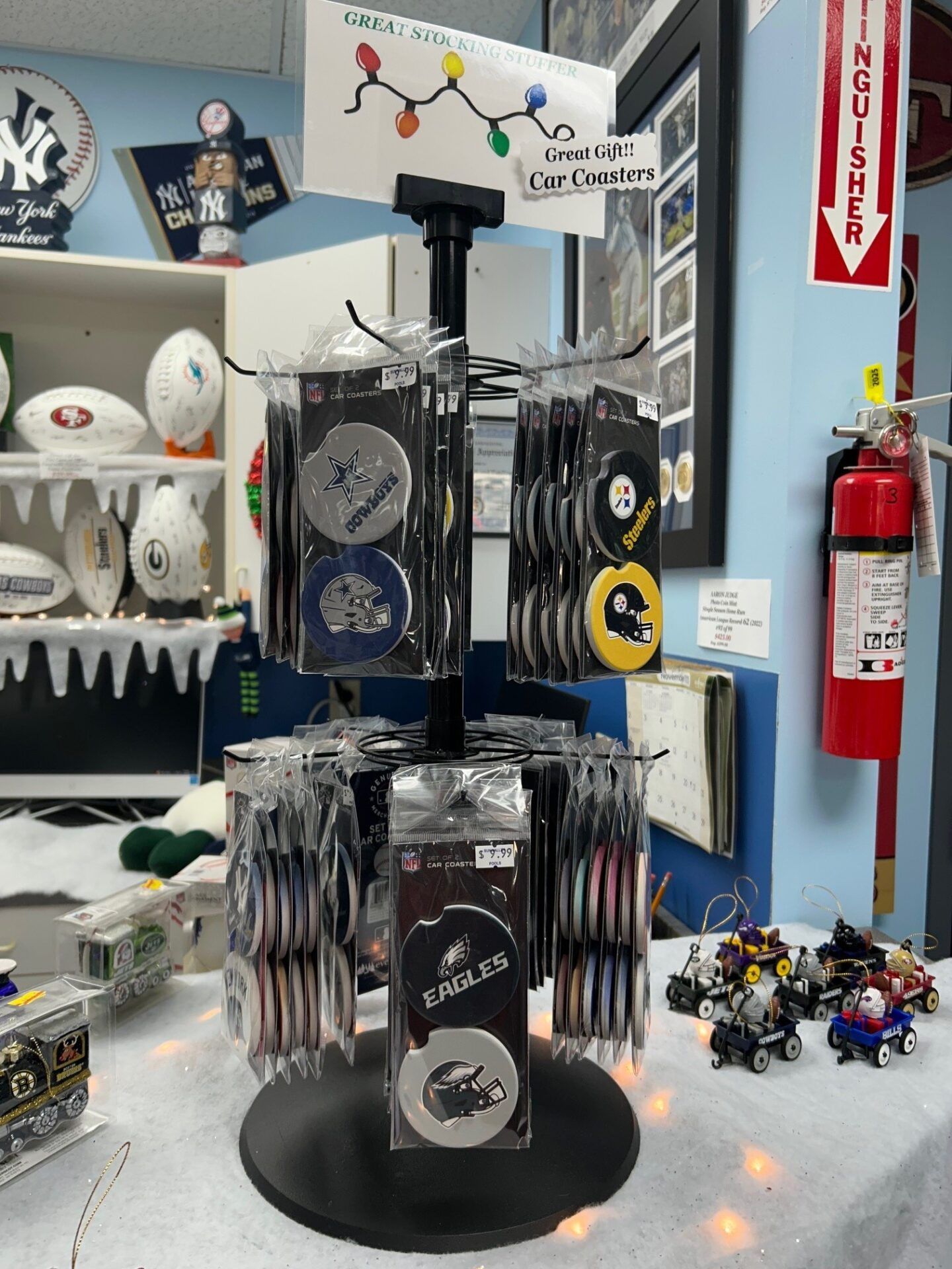 Gift shop display of souvenir keychains, magnets, and small toys on rotating racks and shelves