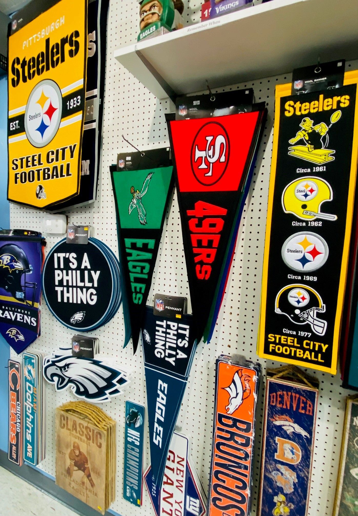 Collection of Pittsburgh Steelers pennants and banners on a wall, in black, gold, and white