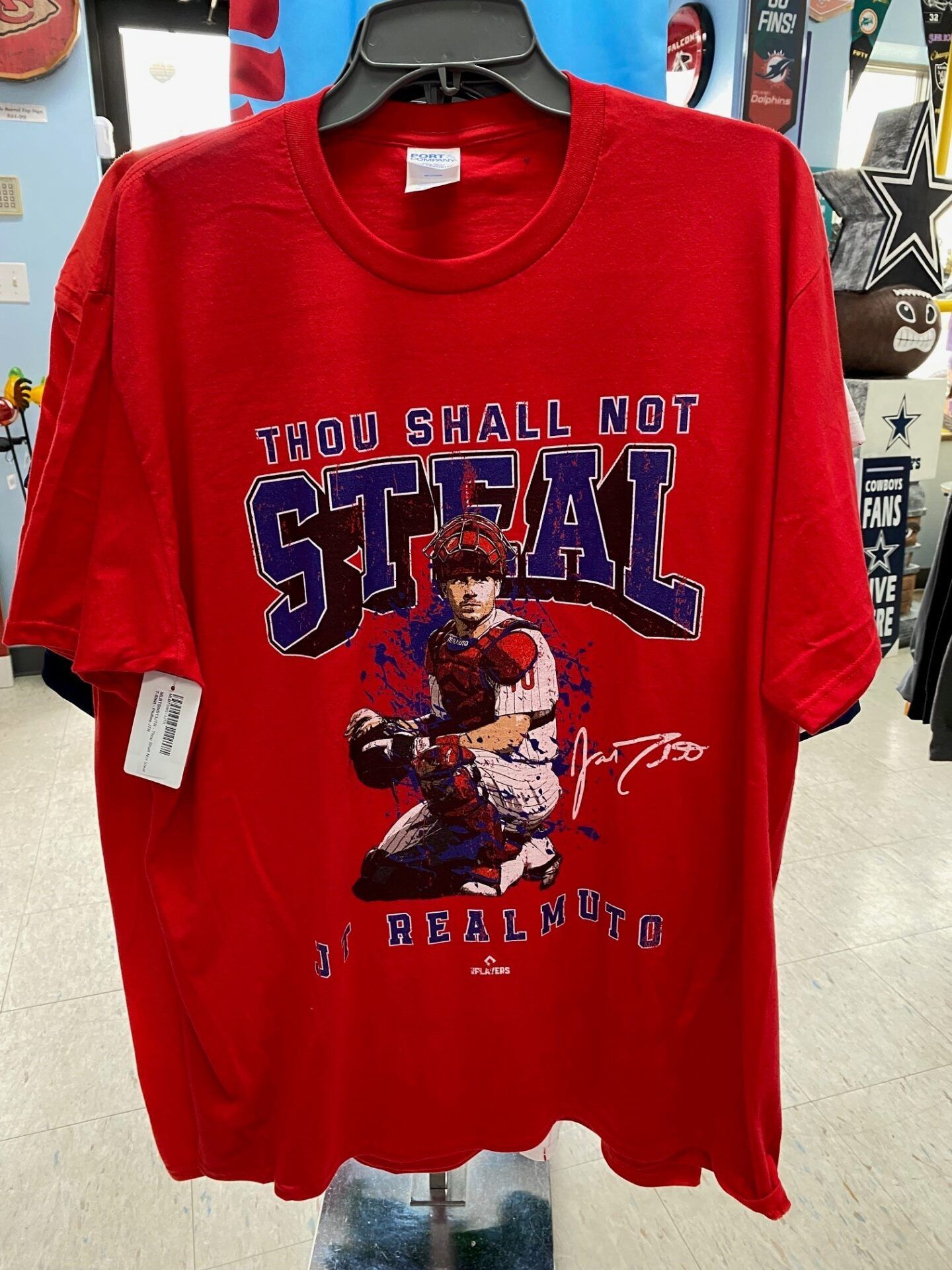 Red T-shirt with a vintage-style sports graphic and the words “THOU SHALT NOT STEAL” and “REAL MEN.”