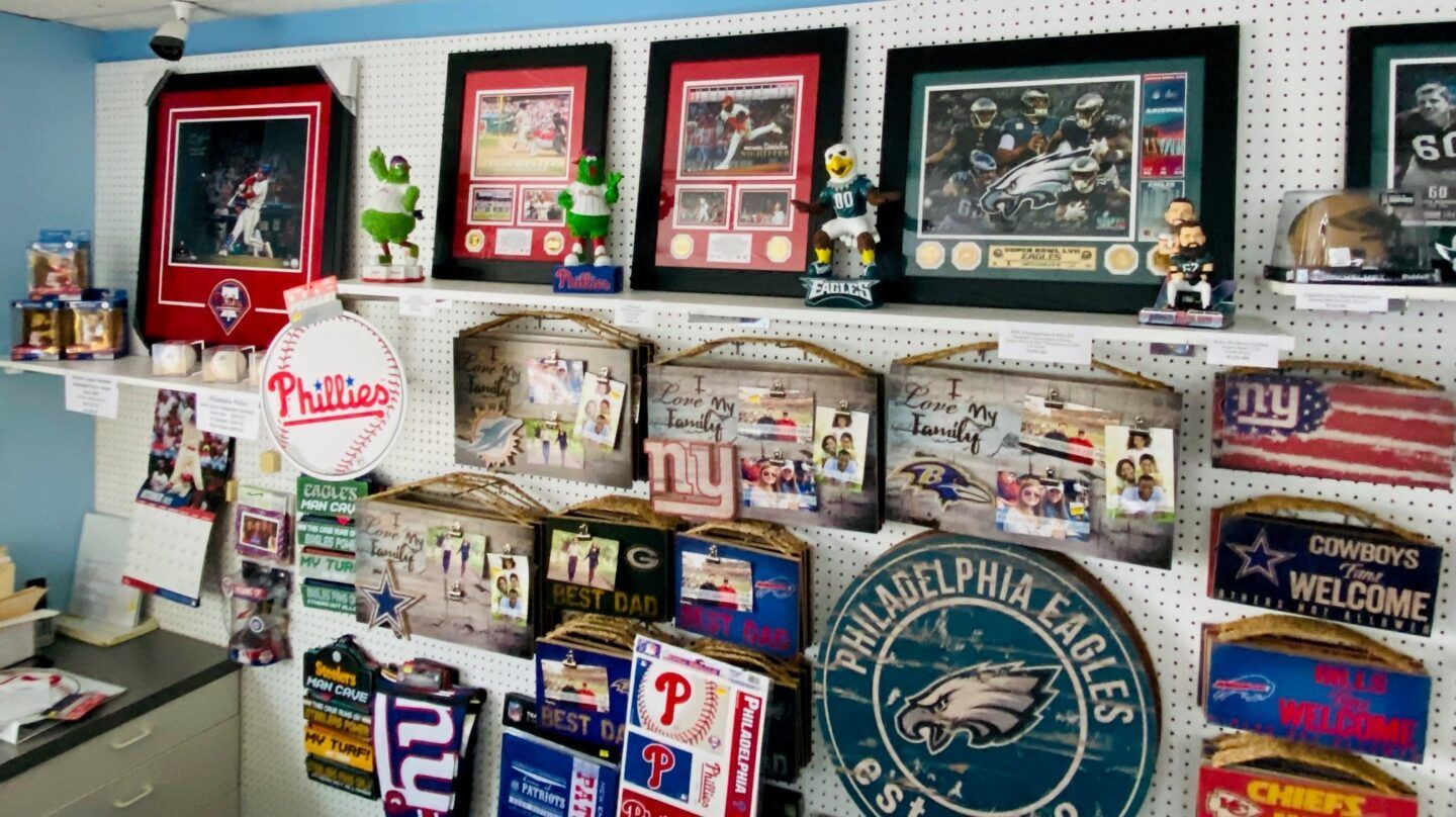 Wall of Philadelphia Eagles memorabilia and framed sports art on shelves and a white wall