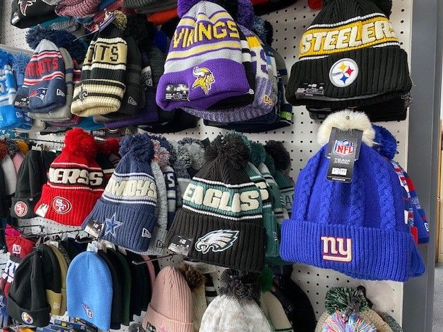 Knitted NFL team hats on a store display, including Vikings, Steelers, Eagles, Bears and Giants logos