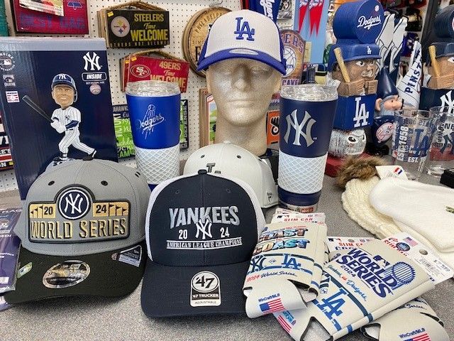 Yankees-themed merchandise display with hats, mugs, shirts, and a mannequin bust in a white LA cap