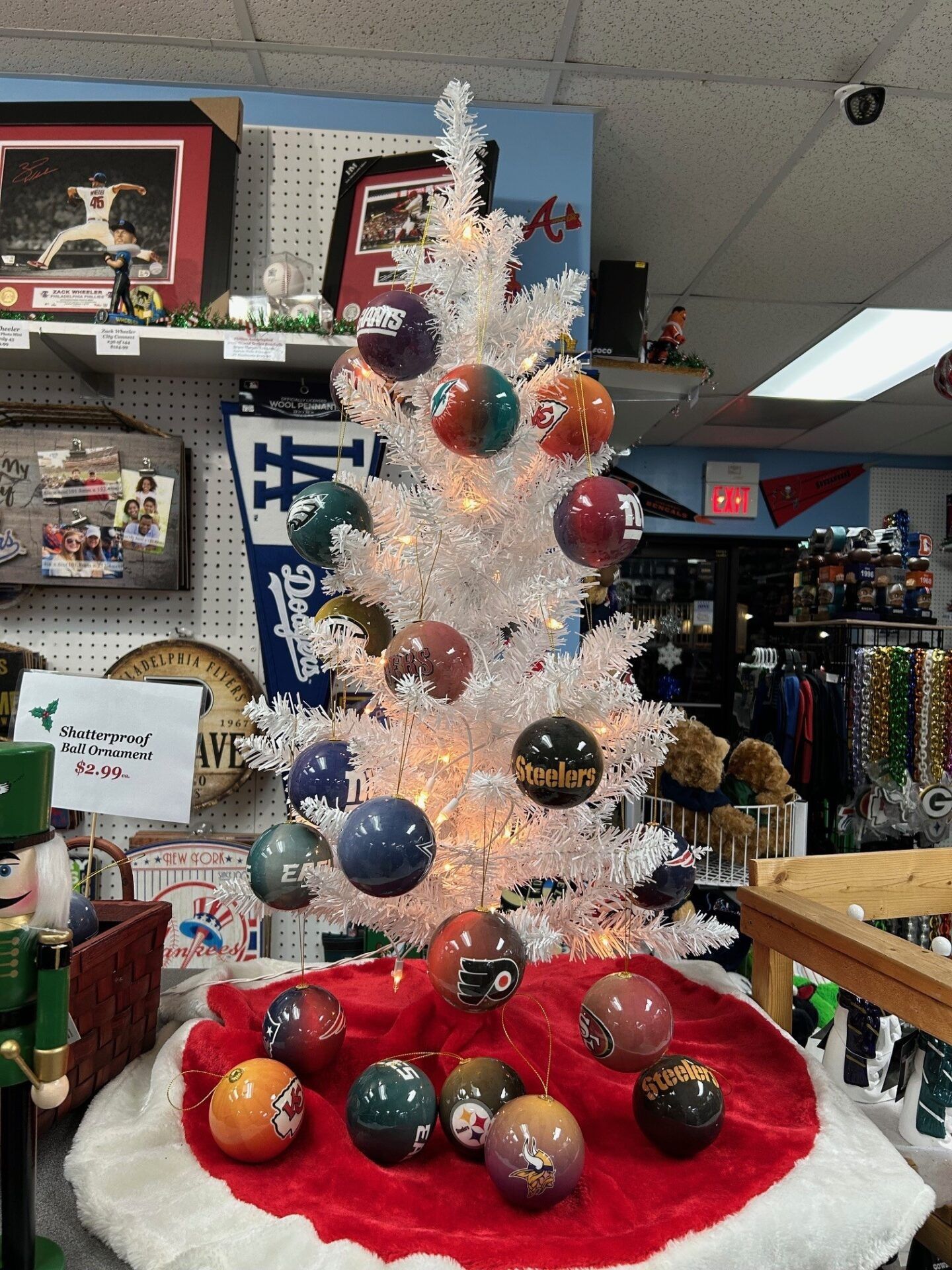 White Christmas tree with colorful ornaments in a store display on a red base