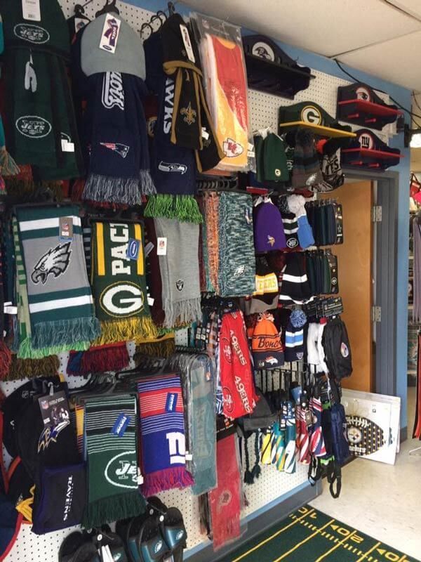 Wall of Green Bay Packers jerseys, hats, and sports merchandise displayed in a shop
