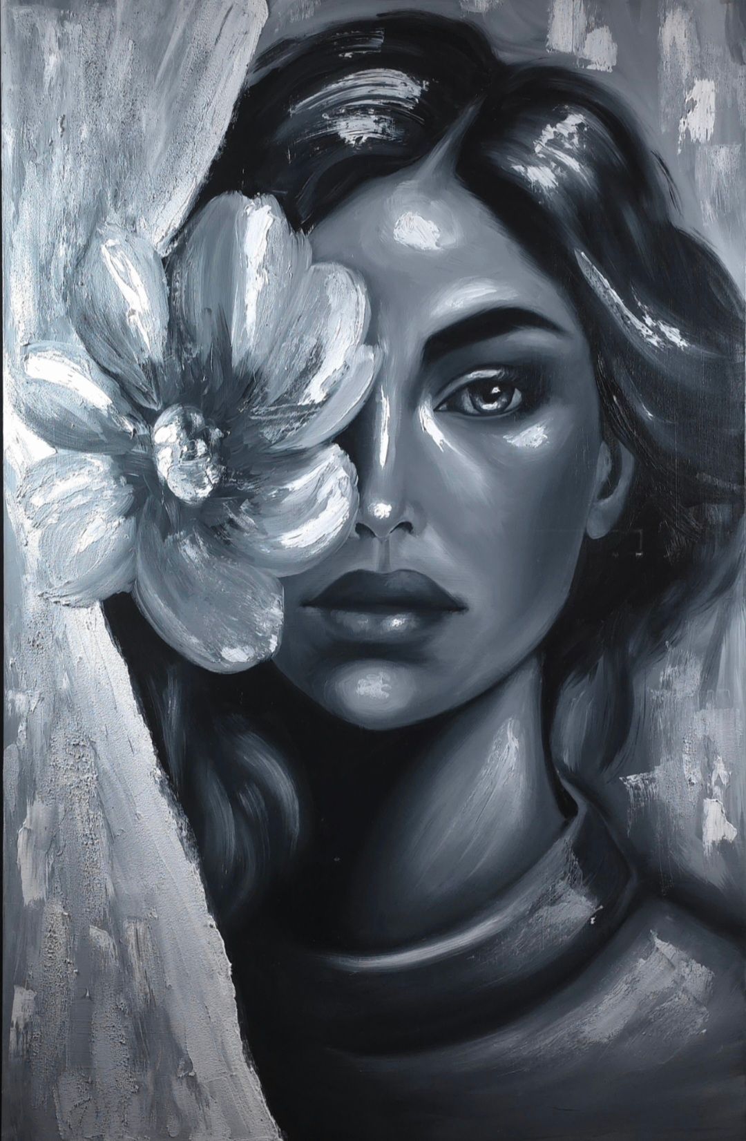 Monochroom portret van een vrouw met een grote bloem boven één oog, die zachtjes voor zich uit kijkt.