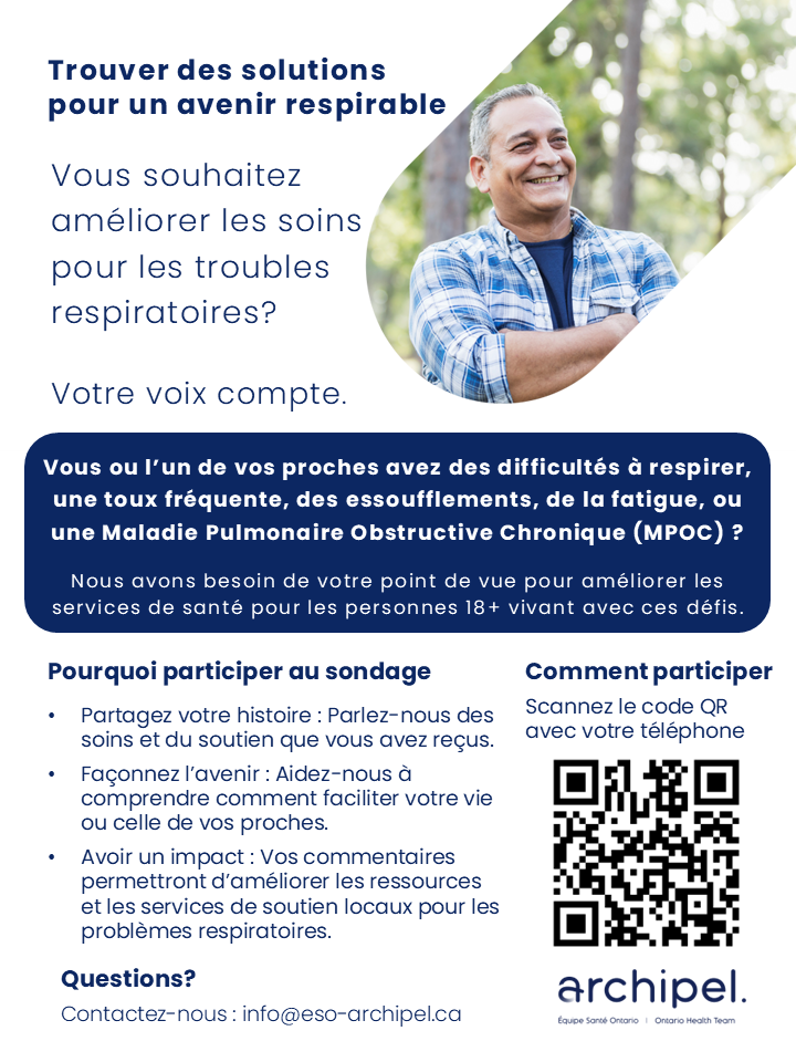 Un homme en chemise à carreaux sourit avec les bras croisés.
