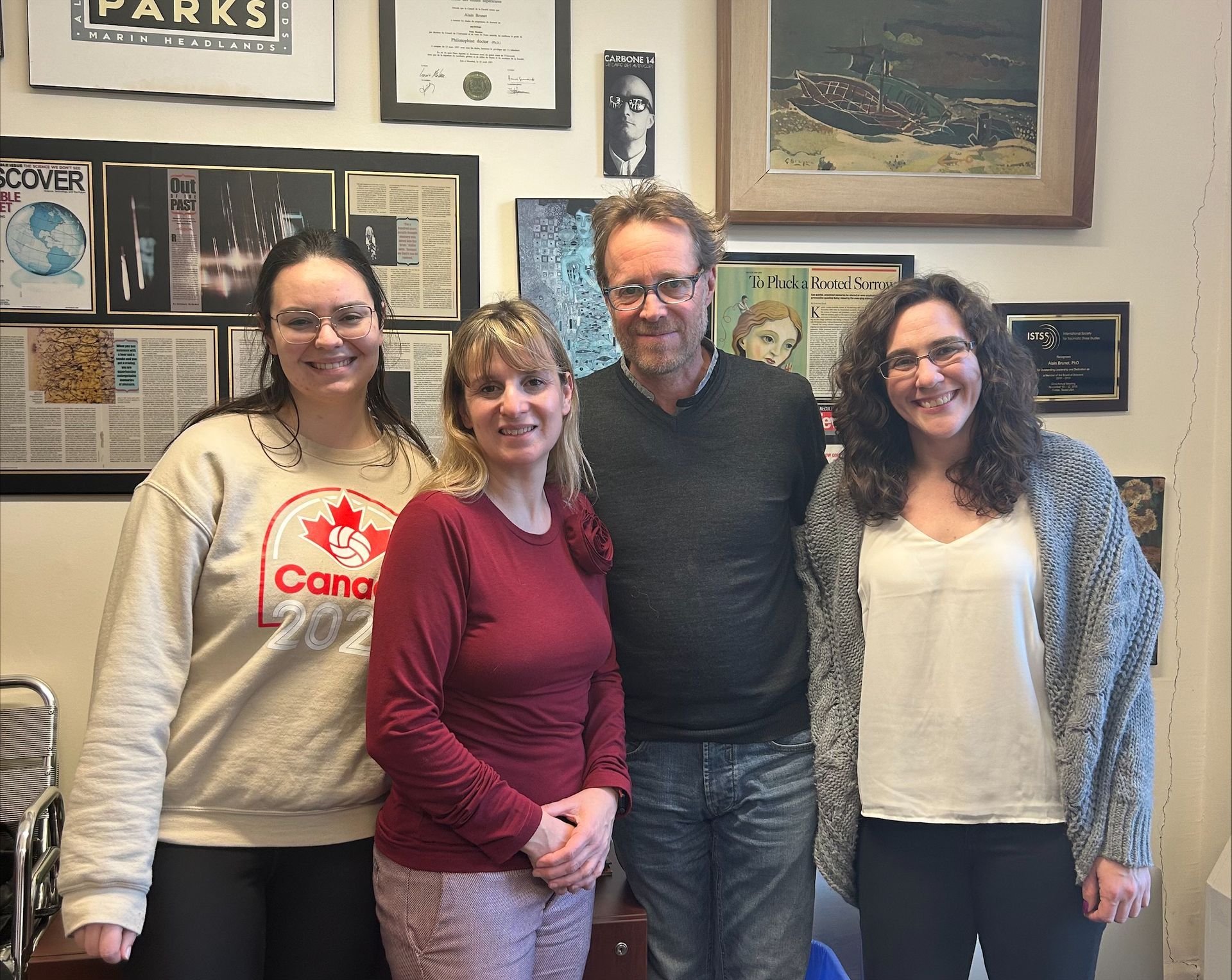 Un groupe de personnes posant pour une photo, l'une d'elles portant un t-shirt canadien