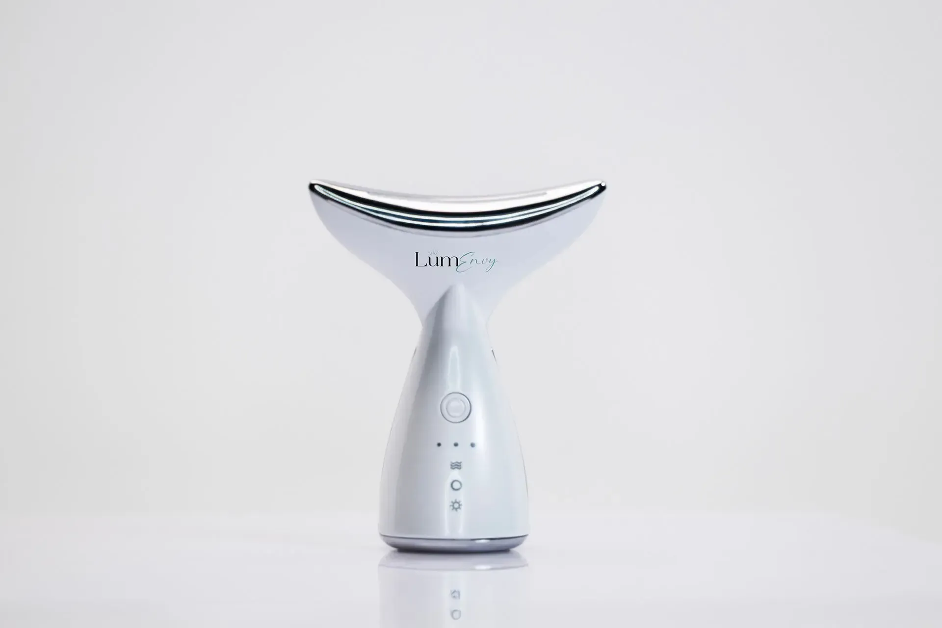 A white, whale-tail shaped facial beauty device with a silver metal treatment head, centered against a white background.