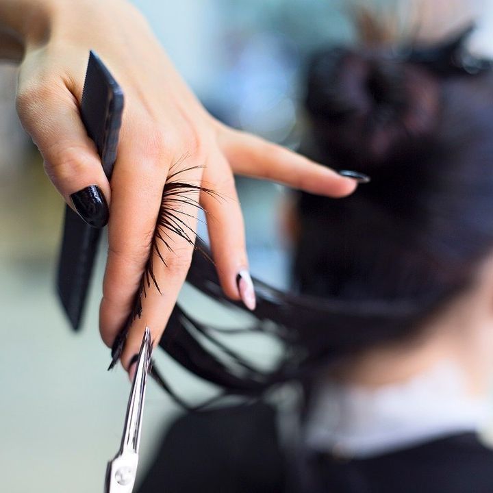 A woman is getting her hair cut by a hairdresser