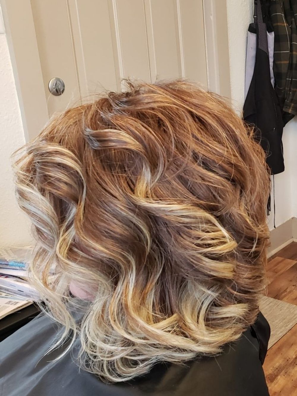 A woman is sitting in a chair with her hair in a bun.