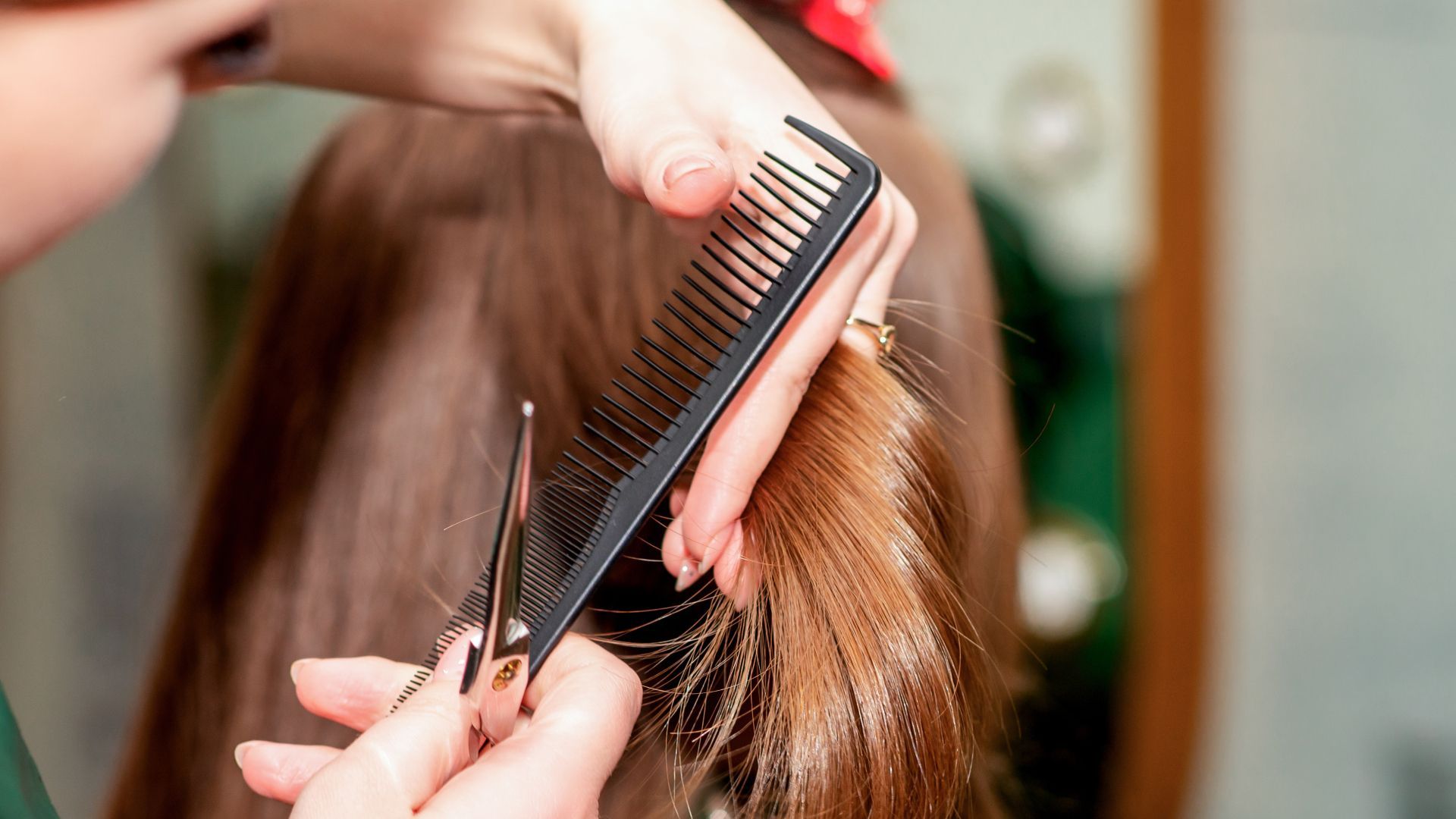 A woman is getting her hair cut by a hairdresser.