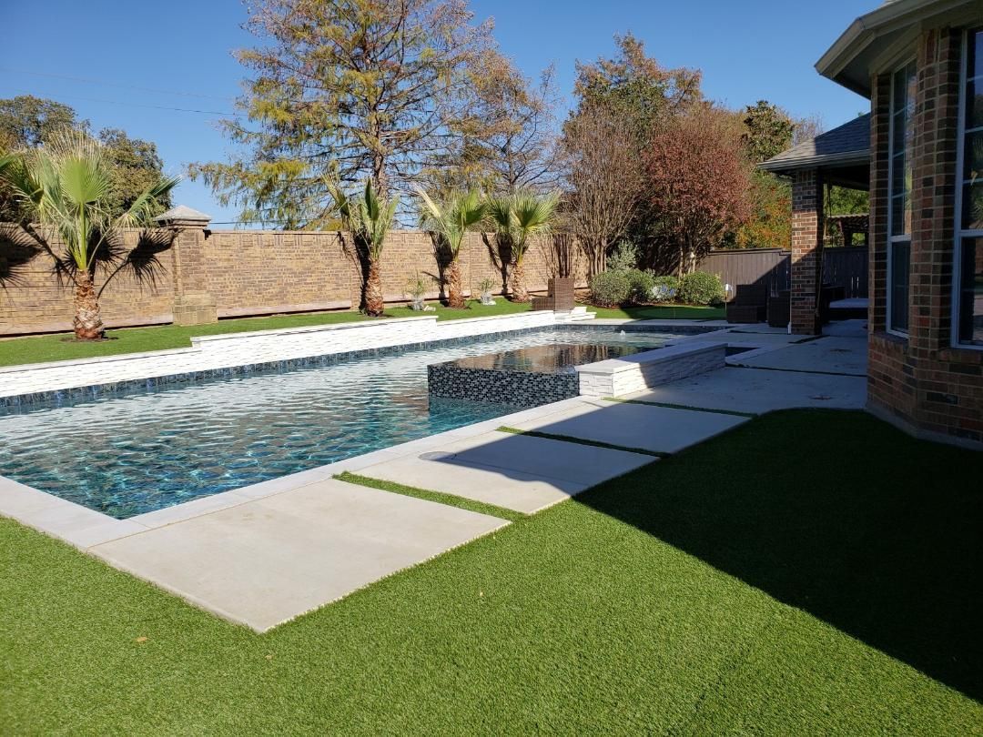 There is a large swimming pool in the backyard of a house.