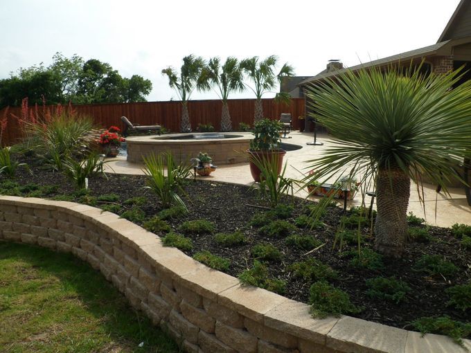 A backyard with a brick wall and a swimming pool