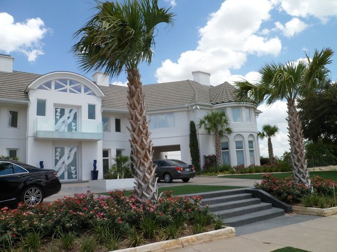A large white house with palm trees in front of it
