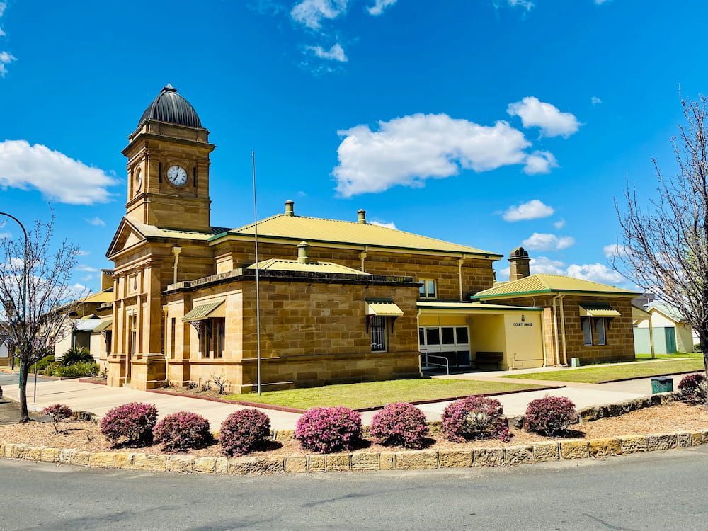 A Large Stone Building with A Clock Tower on Top of It — Sportstar Screenprinting in Warwick, QLD