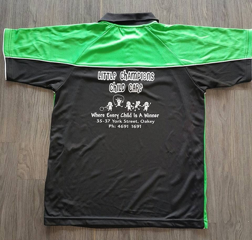 A Black And Green Shirt That Says Little Champions Child Care — Sportstar Screenprinting In Newtown, QLD
