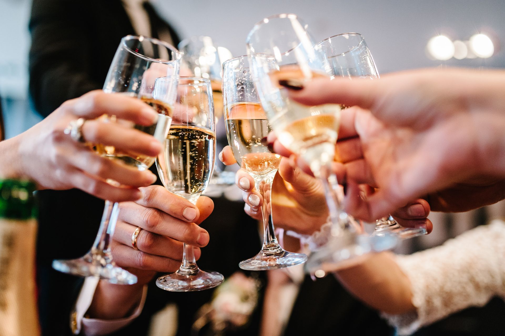 Hands raising champagne glasses in a celebratory toast at a party Hands raising champagne glasses in a celebratory toast at a party