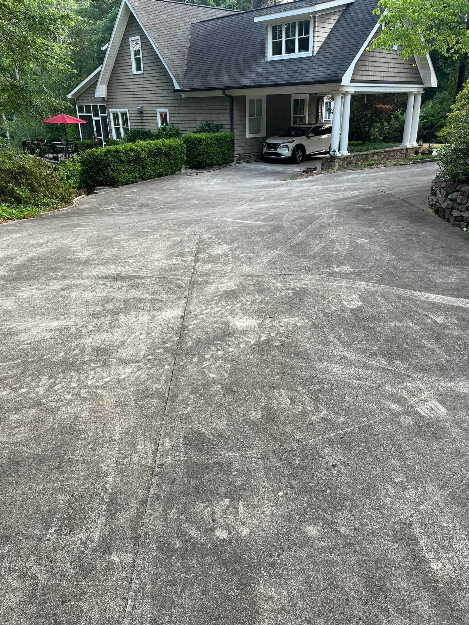 A car is parked in a driveway in front of a house.