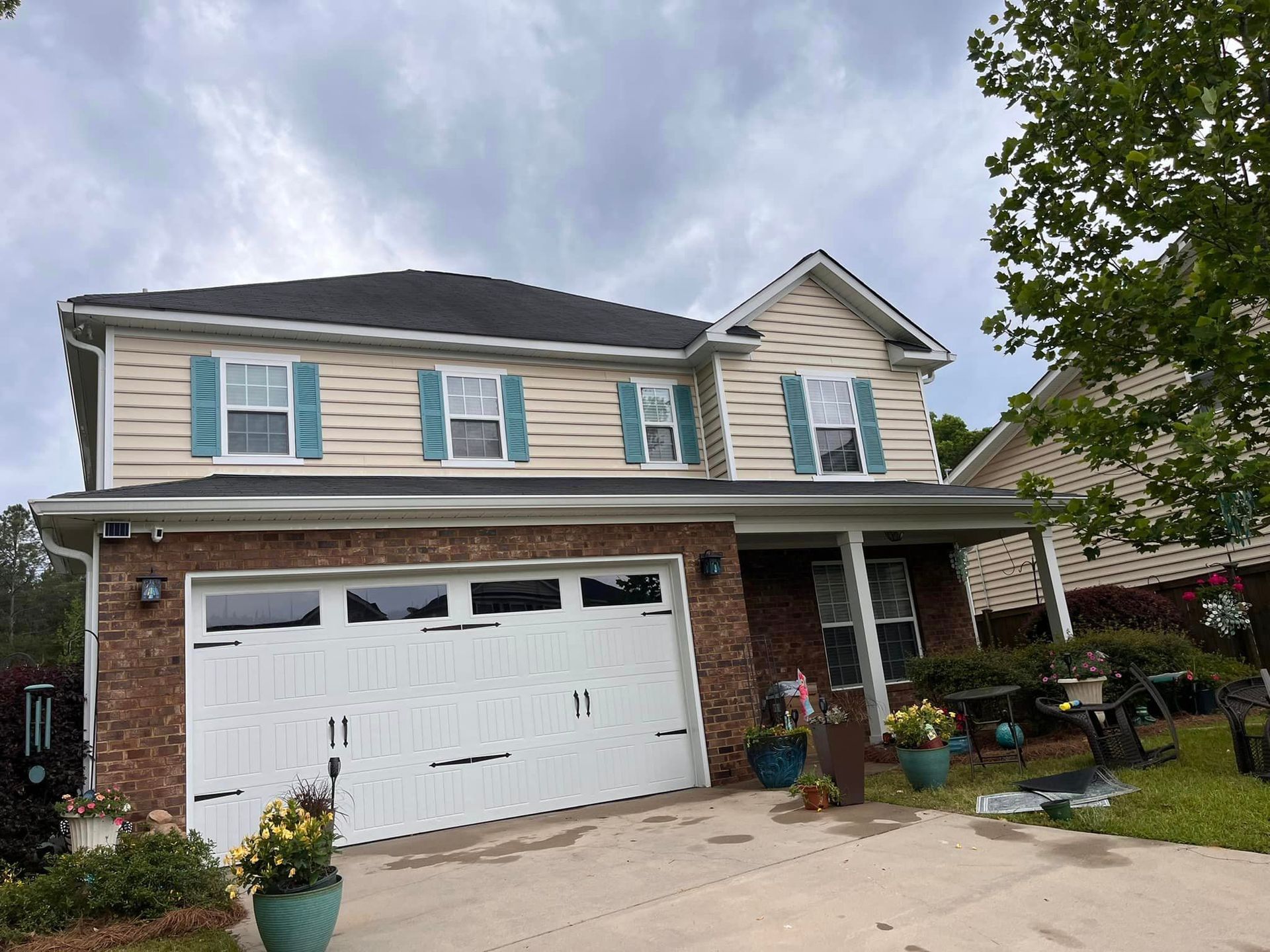A large house with a white garage door and blue shutters.