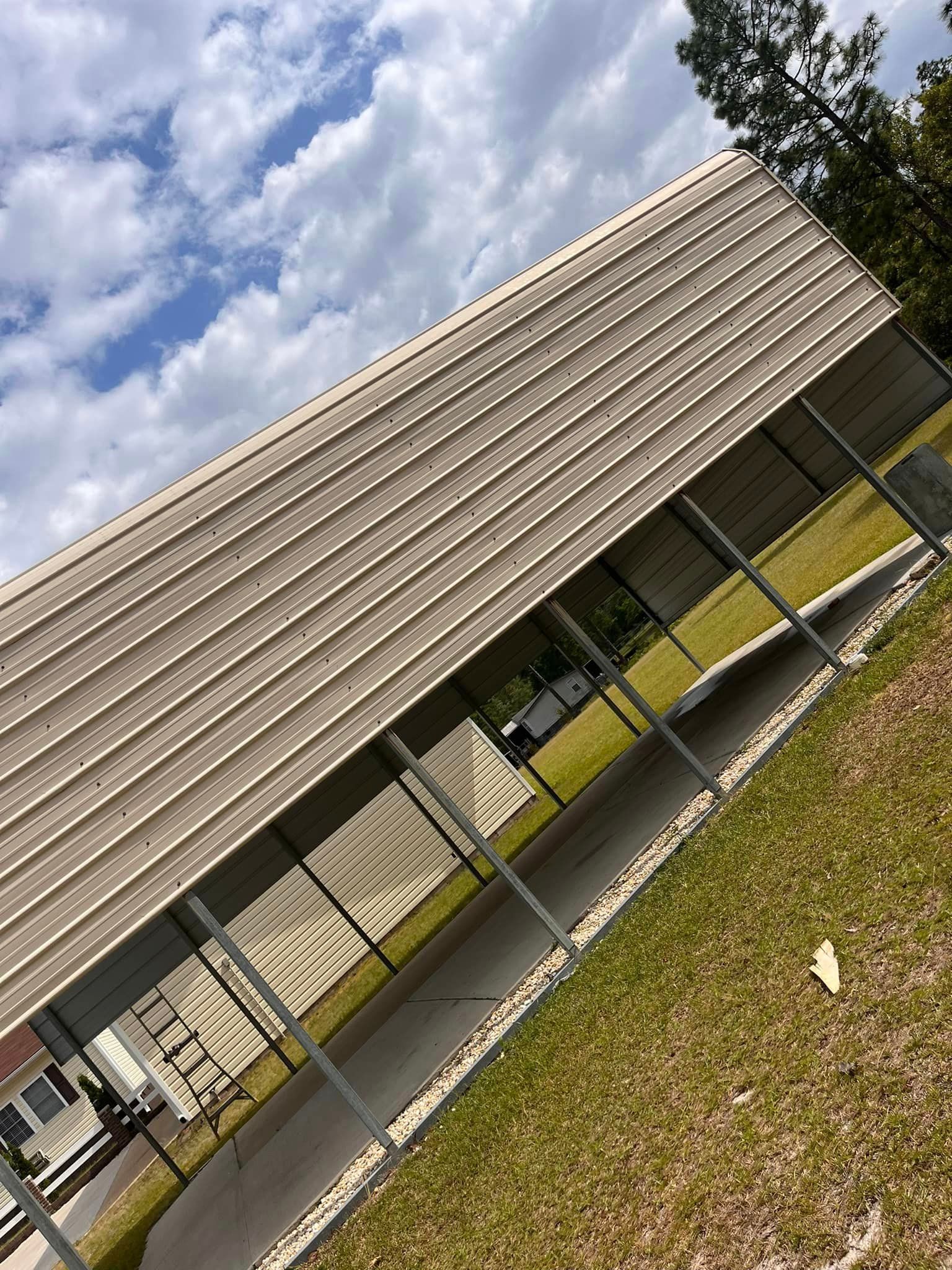 A fenced in area with a covered walkway leading to a building.